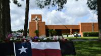 Des fleurs et un drapeau texan en hommage aux victimes, devant le lycée de San Fe le 19 mai 2018 [Brendan Smialowski / AFP]