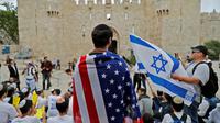 Un Israélien porte un drapeau américain à Jérusalem, avant l'inauguration de l'ambassade.