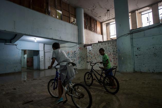 Des enfants font du vélo dans un immeuble squatté de la banlieue de Sao Paulo au Brésil, le 14 mai 2018 [NELSON ALMEIDA / AFP/Archives]