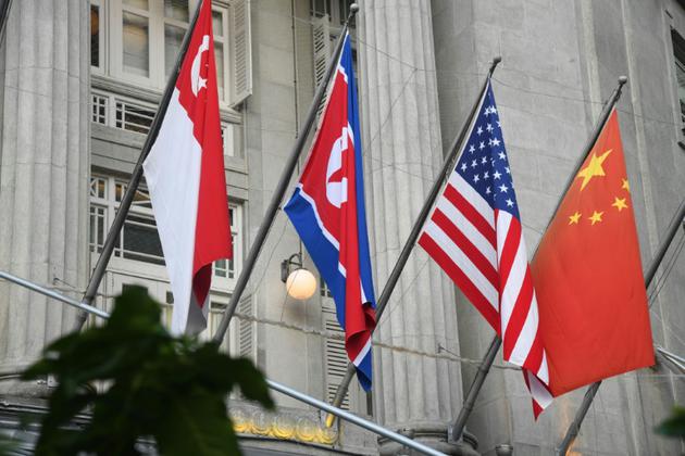 Les drapeaux nord-coréen, américain, chinois et de Singapour sur la façade d'un hôtel de Singapour, le 8 juin 2018  [ROSLAN RAHMAN / AFP]