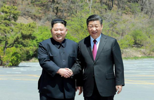 Photo fournie le 9 mai 2018 par l'agence nord-coréenne Kcna du leader nord-coréen Kim Jong Un (g) et du président chinois Xi Jinping, lors d'une rencontre à Dalian le 8 mai 2018, en Chine [KCNA VIA KNS / KCNA VIA KNS/AFP/Archives]