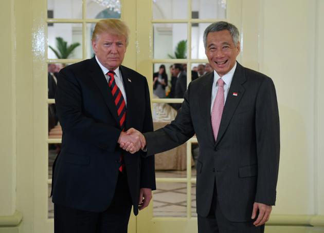 Donald Trump salue le Premier ministre de Singapour, Lee Hsien Loong, le 11 juin 2018 à Singapour, à la veille de la rencontre historique avec le dirigeant nord-coréen Kim Jong Un. [SAUL LOEB / AFP]