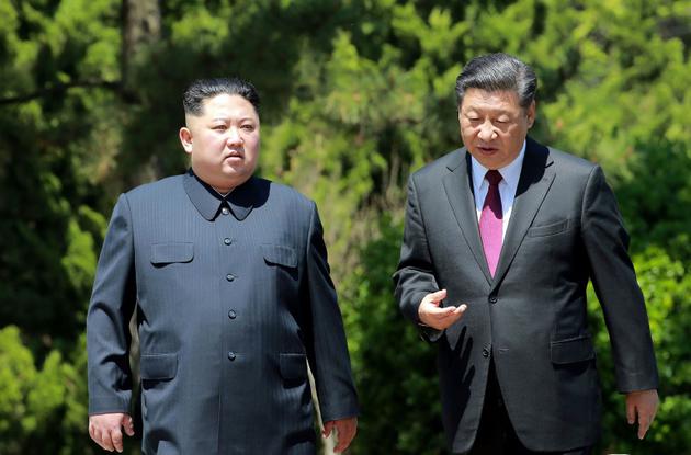 Photo fournie le 9 mai 2018 par l'agence nord-coréenne Kcna du leader nord-coréen Kim Jong Un (g) et du président chinois Xi Jinping, lors d'une rencontre à Dalian le 8 mai 2018, en Chine [KCNA VIA KNS / KCNA VIA KNS/AFP/Archives]