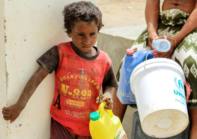 Un enfant yéménite attend son tour pour remplir de l'eau dans un camp de déplacés installé à Khokha pour les habitants ayant fui la ville proche de Hodeida, cible d'une offensive gouvernementale, le 22 juin 2018 [Saleh Al-OBEIDI / AFP]