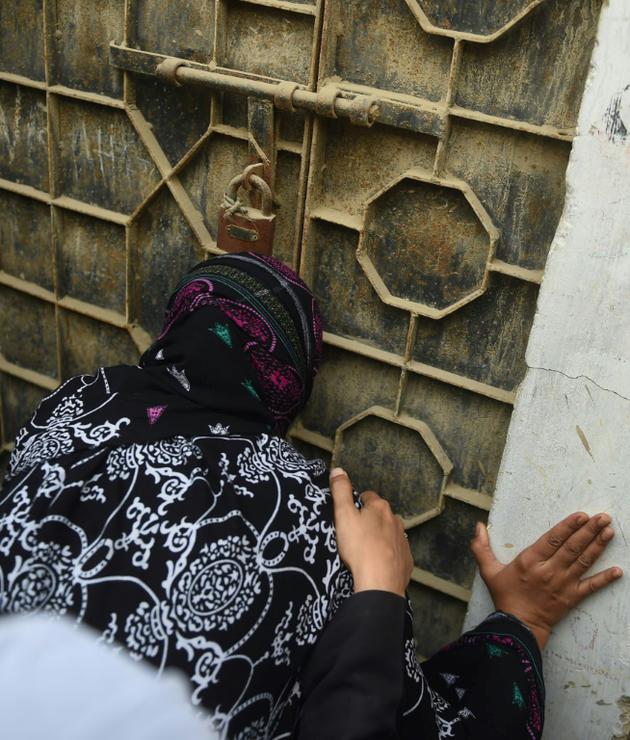 L'ancienne détenue Asma Nawab embrasse la porte de sa maison qu'elle va retrouver, à Karachi au Pakistan, le 7 avril 2018 [RIZWAN TABASSUM / AFP]