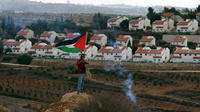 Un protestataire palestinien face à une colonie israélienne