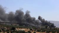 Une photo prise le 4 septembre 2018 montre de la fumée s'élevant de bâtiments visés par des raids aériens dans une localité rebelle de la province d'Idleb en Syrie [OMAR HAJ KADOUR / AFP]