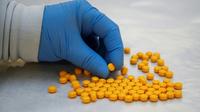 Un agent de l'agence américaine de lutte contre la drogue (DEA) examine des médicaments confisqués contenant du fentanyl, le 8 octobre 2019 dans un laboratoire de New York [Don Emmert / AFP]