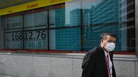 Un homme masqué passe devant un écran de la Bourse de Tokyo en chute, le 13 mars 2020 [Philip FONG / AFP]