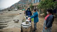 Une religieuse sert de la nourriture dans une soupe populaire d'un quartier pauvre de Lima (Pérou) le 28 mai 2020, où les habitants souffrent de la crise économique entraînée par la pandémie de nouveau coronavirus  [Ernesto BENAVIDES / AFP]