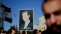 Des manifestants brandissent une photo du président syrien Bachar al-Assad à Qamichli, dans le nord du pays, le 23 décembre 2018 demandant la protection de l'armée [Delil SOULEIMAN / AFP]