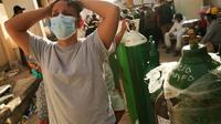 Des proches de malades du Covid-19 font la queue pour faire recharger des bouteilles d'oxygène à l'hôpital d'Iquitos, au Pérou, le 14 mai 2020 [Cesar Von BANCELS / AFP]