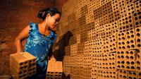 Une cambodgienne travaille dans une fabrique de briques dans la banlieue de Phnom Penh, le 11 décembre 2018 [TANG CHHIN Sothy / AFP]