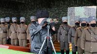 Le leader nord-coréen Kim Jong Un regarde à la jumelle un exercice militaire, le 28 février 2020 dans un lieu non précisé [STR / KCNA VIA KNS/AFP/Archives]