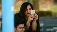 Une étudiante utilise un smartphone sur le campus d'Islamabad le 12 juillet 2018 [Aamir QURESHI / AFP]