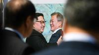 Les visiteurs d'une exposition visant à soutenir le nouveau sommet bilatéral prévu cette semaine en Corée du nord contemplent, lundi 17 septembre 2018 à Séoul, la photo d'une précédente rencontre entre le président sud-coréen Moon Jae-in et le leader nord-coréen Kim Jong Un. [Jung Yeon-je / AFP]