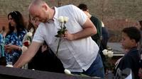 Will Beck, un des rescapés du massacre, plaçant des fleurs sur le mémorial érigé pour les 20 ans de Columbine [Jason Connolly / AFP]