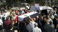 Photo diffusée par l'agence de presse officielle syrienne Sana montrant des hommes transportant le cercueil de l'une des victimes des attaques commises le 25 juillet 2018 par le groupe jihadiste Etat islamique (EI), lors de funérailles le 26 juillet 2018 dans la ville de Soueida, dans le sud de la Syrie [STR / SANA/AFP]