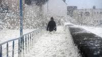 Une personne enveloppée par l'écume des vagues lors du passage de la tempête Dennis, le 16 février 2020 à Saint-Guénolé, dans le Finistère [Fred TANNEAU / AFP]