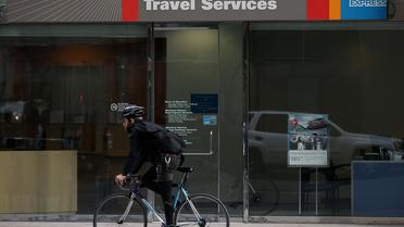 Un cycliste passe devant une agence American Express Travel Services, le 11 janvier 2013 à San Francisco [Justin Sullivan / AFP/Getty Images/Archives]