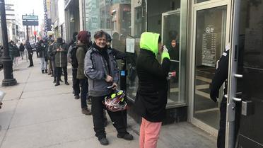 De longues files d'attente se forment devant les magasins de vente de cannabis, comme ici à Montréal. 
