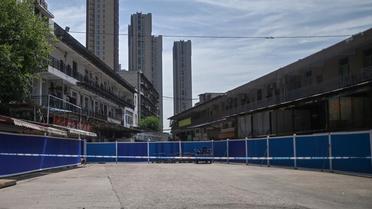 Le marché aux animaux de Wuhan est fermé depuis le 1er janvier et est désormais caché derrière une longue palissade bleue. 