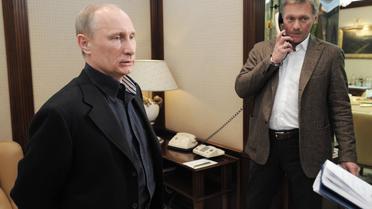 Le président russe Vladimir Poutine (g) et son porte-parole Dmitri Peskov, le 4 mars 2012 à Moscou [Alexey Druzhinin / Ria Novosti/AFP/Archives]