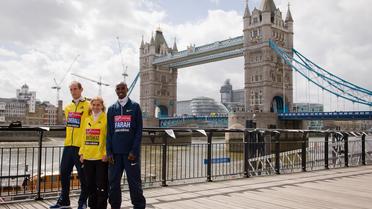 Les athlètes britanniques Scott Overall (g), Amy Whitehead et le double champion olympique du 5000 et 10.000m Mo Farah, en lice pour le marathon de Londres, posent devant Tower Bridge, le 19 avril 2013 [Leon Neal / AFP]