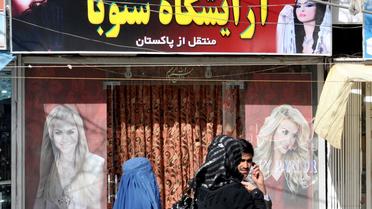 Des femmes en burqa et voilée passent devant un salon de beauté à Kaboul, le 30 septembre 2011 [Adek Berry / AFP/Archives]