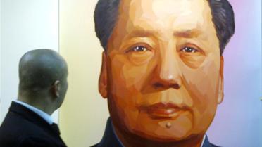 Un homme regarde un portrait de Mao Tsé-toung, l'initiateur de la Révolution culturelle, lors d'un salon d'art contemporain à Pékin, en 2005 [ / AFP/Archives]