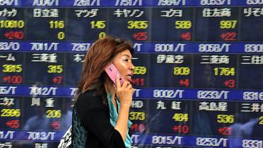 Une passante discute au téléphone dans la rue à Tokyo, en septembre 2011 [Yoshikazu Tsuno / AFP/Archives]