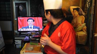 Un cuisinier regarde à la TV le discours du président chinois Hu Jintao, lors du 18e congrès du PCC, le 9 novembre 2012 à Shanghai [Peter Parks / AFP]