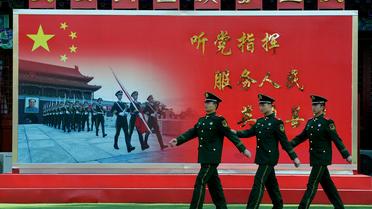 Des policiers défilent devant une inscription affirmant "Sers le Parti et le Peuple", le 12 novembre 2012 à Pékin [Mark Ralston / AFP/Archives]