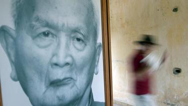 Un touriste passe devant un portrait de Nuon Chea, l'idéologue des Khmers rouges, au musée Tuol Sleng de Phnom Penh, le 29 mars 2013 [Tang Chhin Sothy / AFP/Archives]