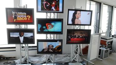Des écrans diffusent les premières images des sept nouvelles chaînes gratuites de la TNT en Ile-de-France, en mars 2008 au siège du CSA [Stephane de Sakutin / AFP/Archives]