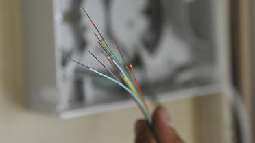 Un technicien installe de la fibre optique dans un appartement à Paris, en 2010 [Bertrand Langlois / AFP/Archives]