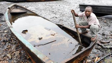 Un habitant de Bodo essaie de séparer le pétrole de l'eau dans un bateau, le 11 août 2011 au Nigeria [Pius Utomi Ekpei / AFP]