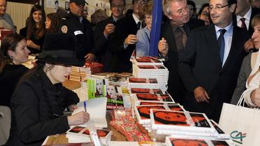 François Hollande, alors candidat à la présidence de la République, présent à la signature du livre d'Amélie Nothomb (g), le 4 novembre 2011 à Brive [Jean-Pierre Muller / AFP/Archives]