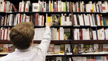 Un employé prend un livre dans une librairie [Francois Guillot / AFP]
