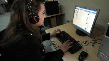 Une jeune femme sur Facebook dans un cyber-café de Tunis, le 13 mars 2013 [Fethi Belaid / AFP/Archives]