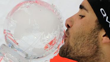 Le Français Martin Fourcade embrasse le grand globe de cristal du biathlon, remporté le 17 mars 2012 après la mass start (15 km) à Khanty-Mansiysk (Russie). [Kirill Kudryavtsev / AFP/archives]