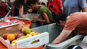 Des gens tentent de récupérer de la nourriture dans des poubelles [Dominique Faget / AFP/Archives]
