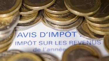 Photo réalisée le 7 septembre 2012 à Paris d'un avis d'imposition sur le revenu et de pièces de 1 euro. [Joel Saget / AFP/Archives]