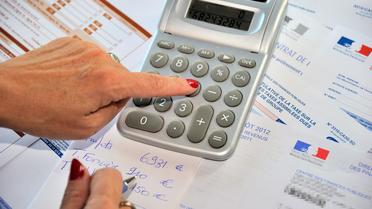 Une femme fait ses calculs pour remplir sa déclaration d'impôts, en septembre 2012 [Philippe Huguen / AFP/Archives]