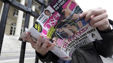 Un homme lit le numéro de Closer qui publie en une des photos dénudées de Kate Middleton le 14 septembre 2012 à Paris