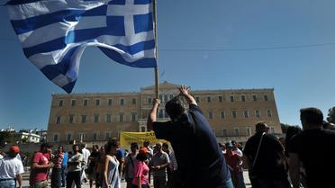 Un manifestant agite un drapeau de la Grèce devant le Parlement lors de protestations contre l'austérité, le 26 septembre 2012 à AThènes [Louisa Gouliamaki / AFP/Archives]