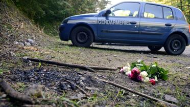 Une voiture de gendarmerie et des fleurs sur les lieux de la tuerie de Chevaline, le 8 septembre 2012 [Philippe Desmazes / AFP/Archives]