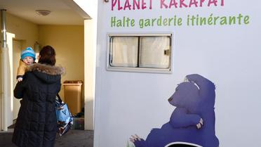Une femme amène son enfant à une crèche itinérante, à Lovagny, en Haute-Savoie [Philippe Desmazes / AFP/Archives]