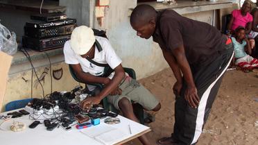 Un client fait recharger son téléphone portable, le 12 février 2013, dans la ville de Xai Xai, au sud du Mozambique [Jinty Jackson / AFP/Archives]