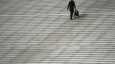 Un homme monte des escaliers dans le quartier de la Défense [Fred Dufour / AFP/Archives]